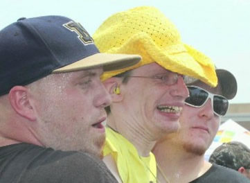 Wearing the yellow hat, Patrick Connelly is helped to the front at a Blake Shelton concert.